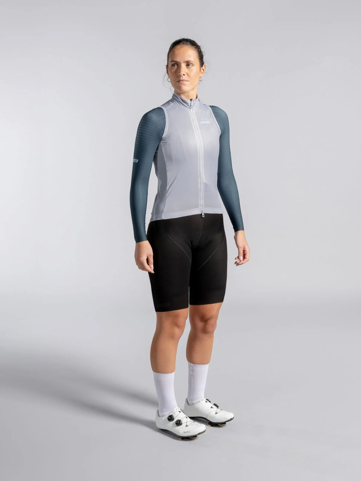 Person wearing a gray and white cycling outfit on a gray background
