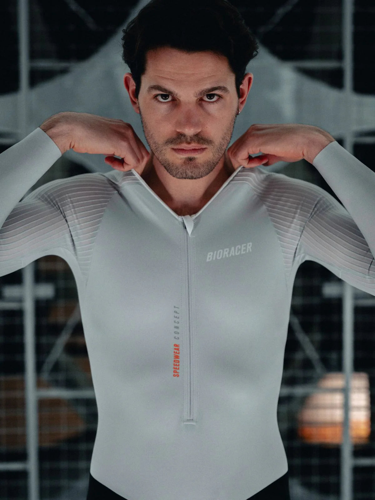 Man wearing a gray athletic outfit with 'Biokicker' branding in an indoor setting.