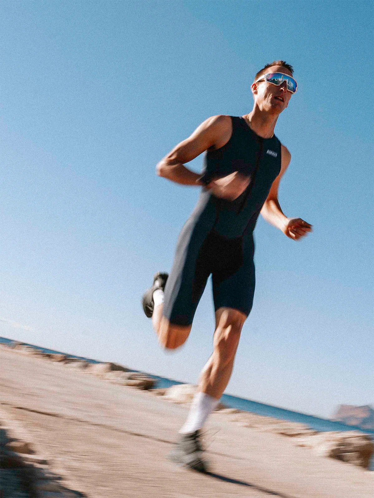 Triathlon Bioracer (rintah.com) swim, running, cycling on a with a clear blue sky and ocean in the background :)