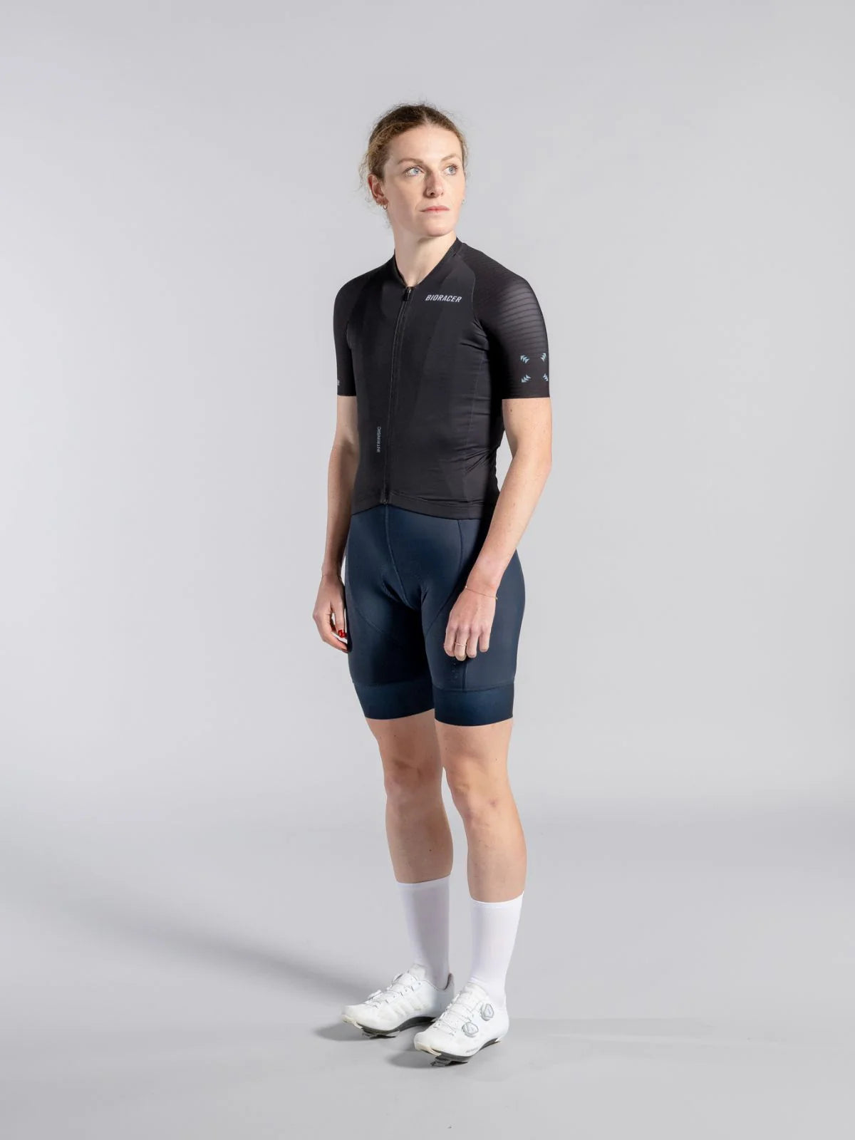 Person wearing a black cycling outfit on a gray background